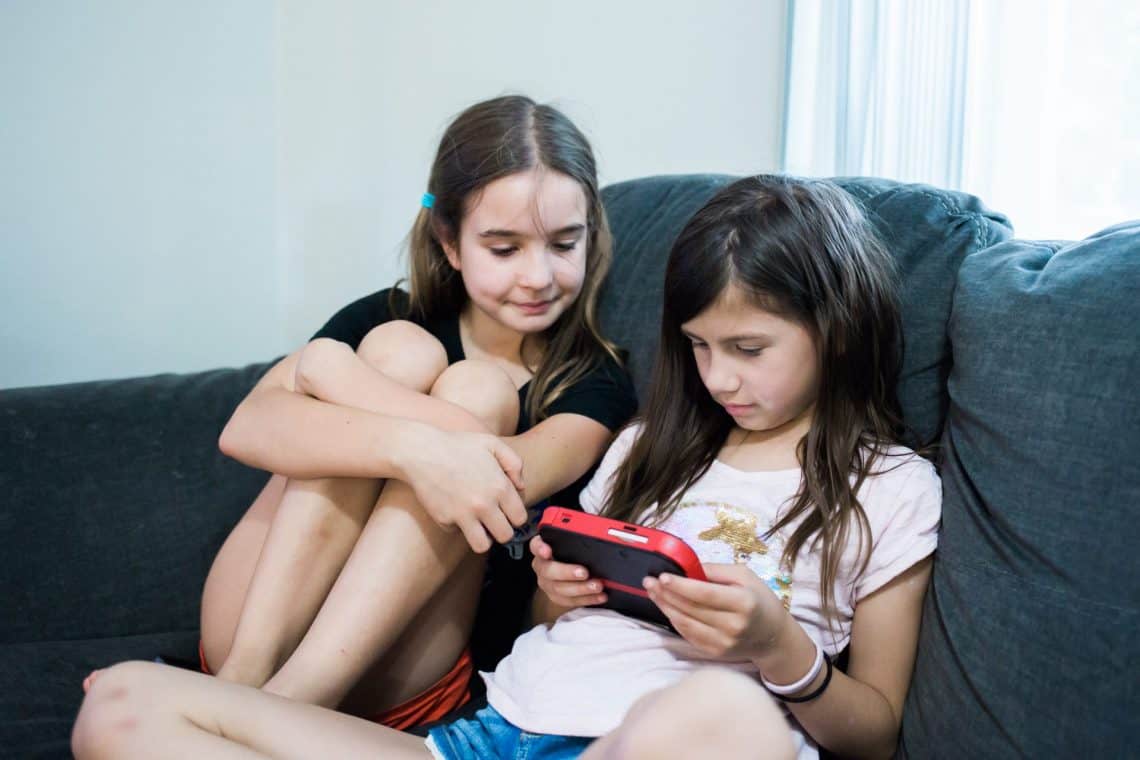 Family Game Night two young girls playing a Nintendo handheld game system
