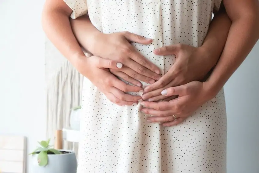 couple hands on a pregnant belly